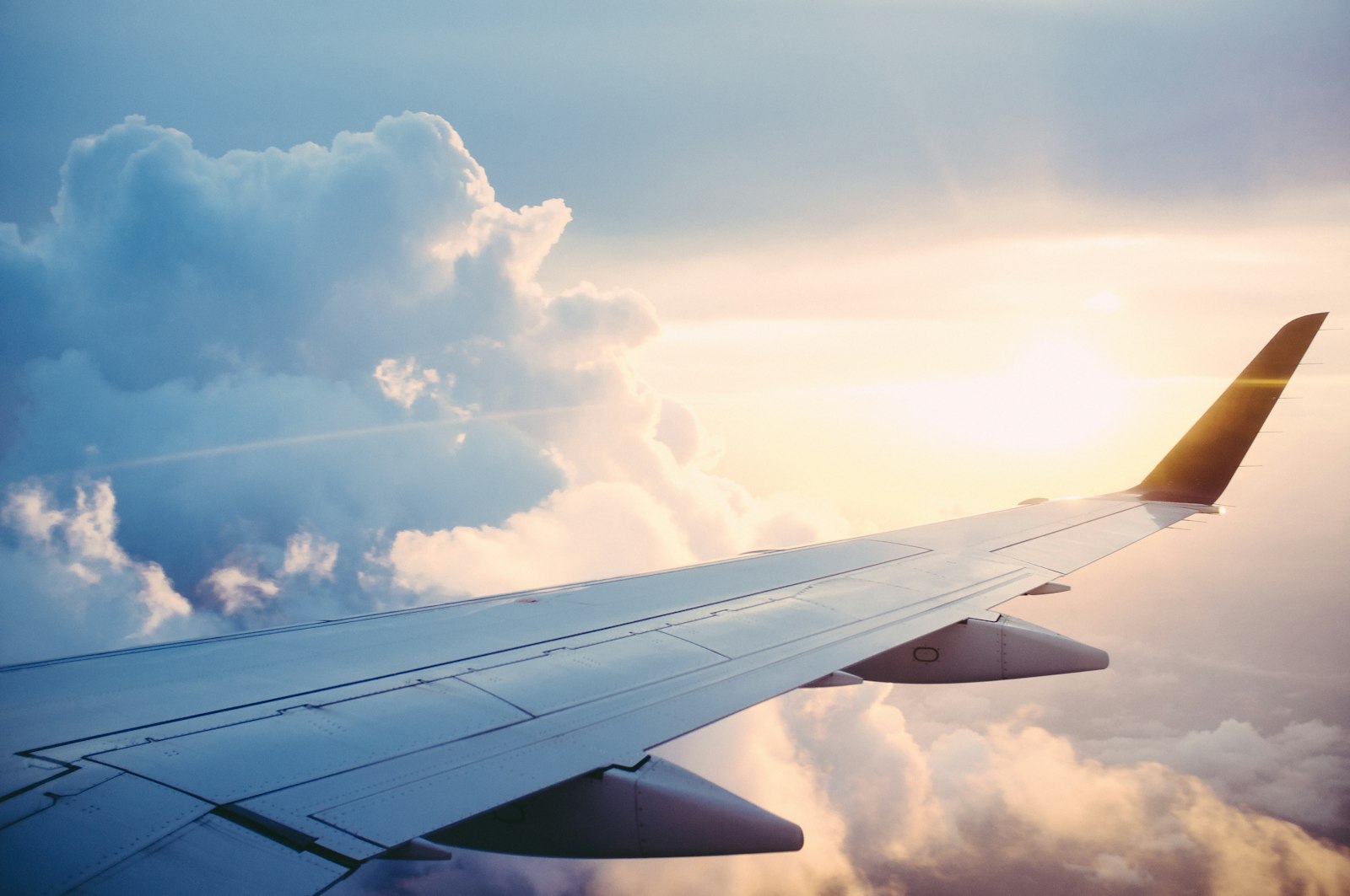 Airplane wing above the clouds at cruising altitude